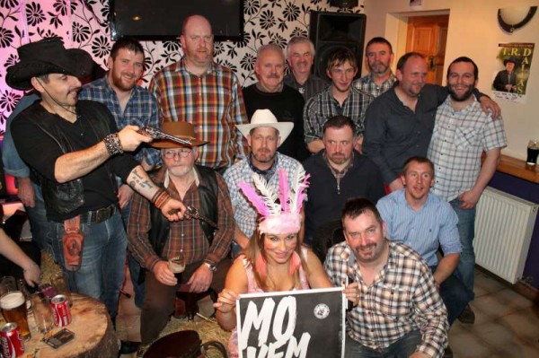 Pictured in "The Pub" at Carriganima the superb group who participated in the recent "Movember" project and who raised a marvellous €2,000.00 for Cancer Research. Jimmy Murphy (on extreme left) was the principal coordinator of the inspiring project with splendid support from Seán and Matt of "The Pub" and a dedicated team of participants who all grew taches throughout November. Caroline (pictured) as Hairdresser Supreme expertly shaved all the taches following our photograph! (Picture by Seán Radley)