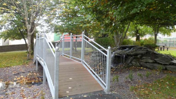 Bridge and water feature near playground.