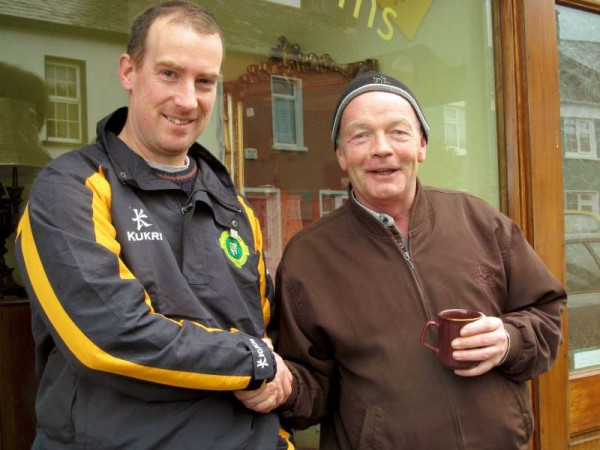 Frank Kirke (on right) on a visit to Millstreet at the weekend wishes Michael Cashman (representing Millstreet Football Club Supporter supreme) every success in the Quarter-Final being played in Mallow on Sunday. Frank of course is a native of West End and has been the superb coordinator of such musical groups as the Kirkebride Band in Co. Kildare and has been a splendid member of Millstreet Pipe Band. Click on the image to enlarge. (S.R.)